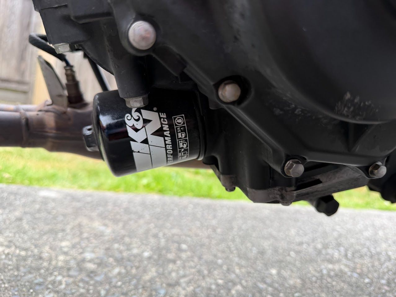Close-up of a motorcycle oil filter installed beside the engine