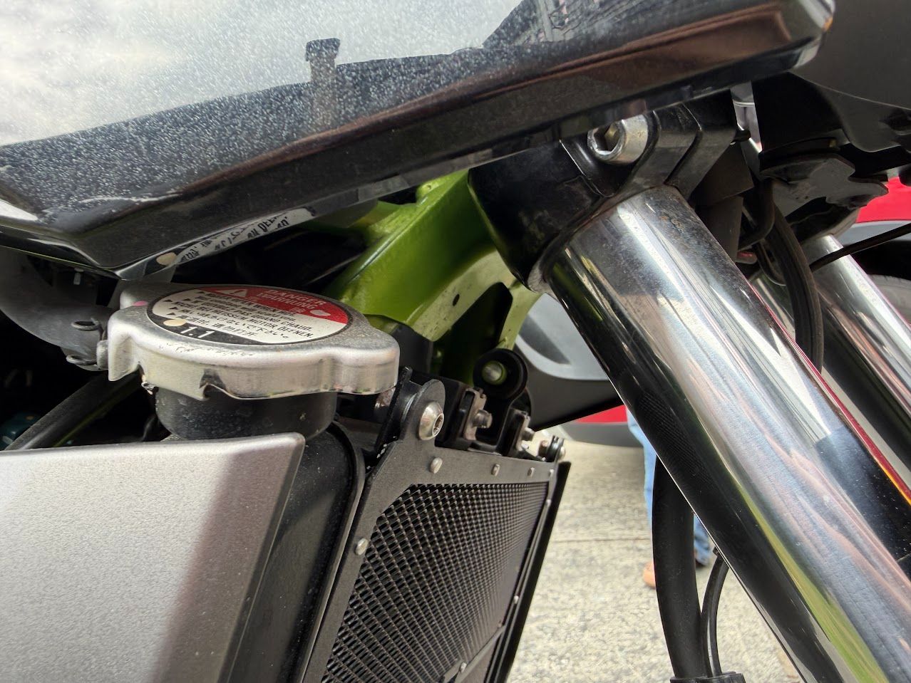 Motorcycle front suspension and radiator area checked after wet-weather riding